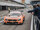 Oranger Mercedes-Rennwagen in der Boxengasse am Hockenheimring, während Zuschauer das Fahrzeug fotografieren.