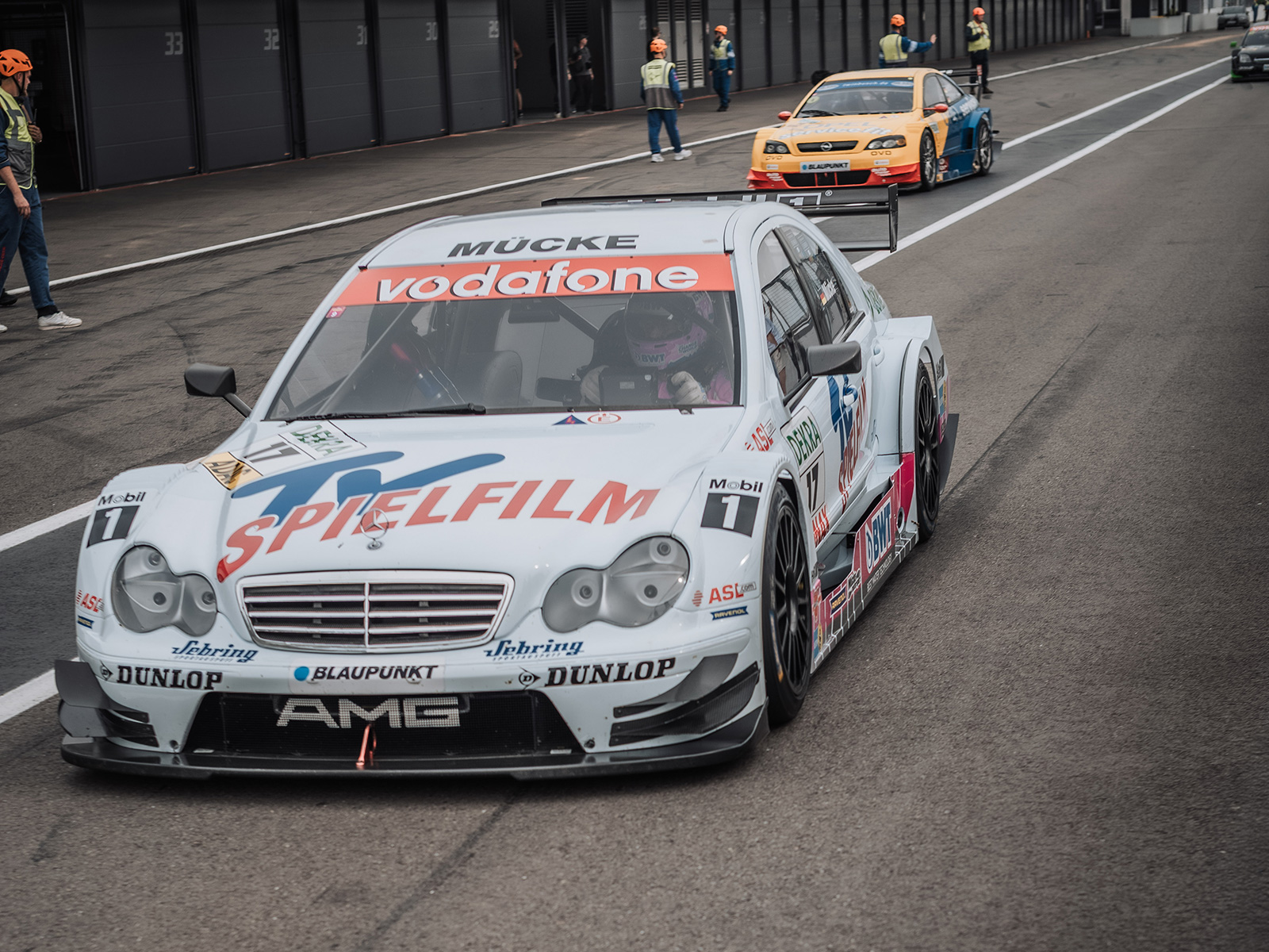 Historische Tourenwagen fahren durch die Boxengasse am Hockenheimring.