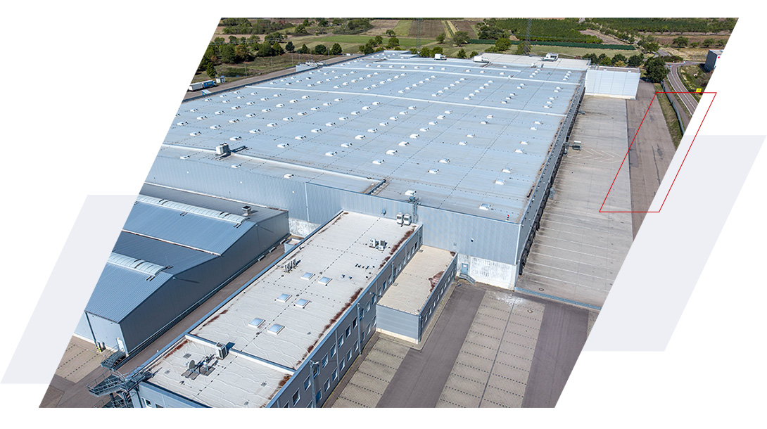 Außenansicht des Logistiklagers in Bietigheim mit großzügigen Freiflächen und Laderampen entlang der Lagerhalle.