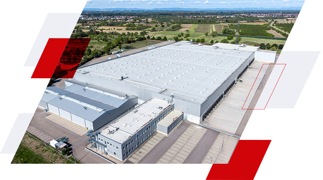 Luftaufnahme des neuen Logistiklagers in Bietigheim mit großflächiger Lagerhalle und zahlreichen Laderampen.
