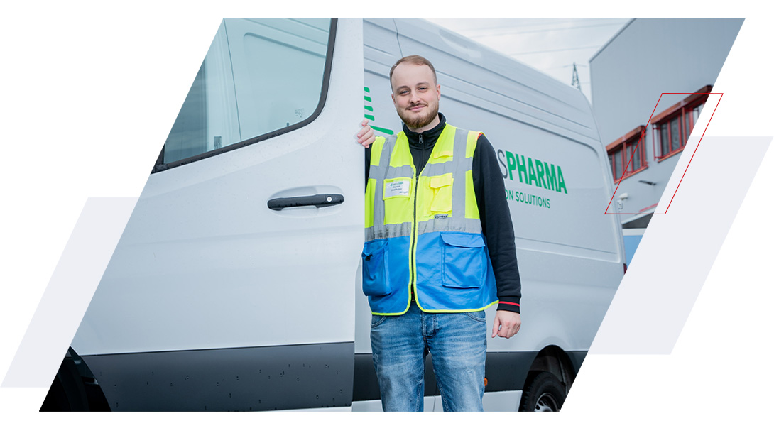 Hartmann-Mitarbeiter in Warnweste steht neben einem Transporter der Pharmalogistik und gibt ein positives Daumen-hoch-Zeichen.